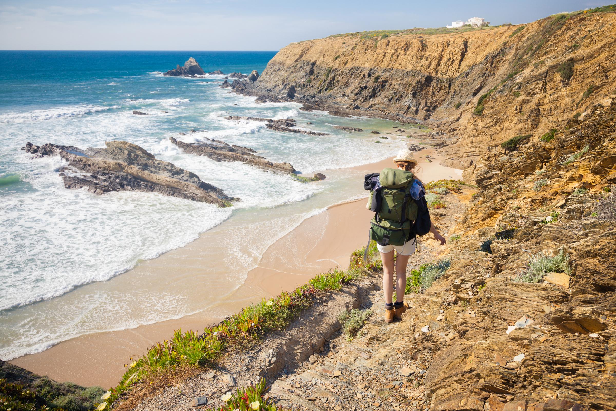 Wanderin mit Rucksack an der portugiesischen Atlantikküste